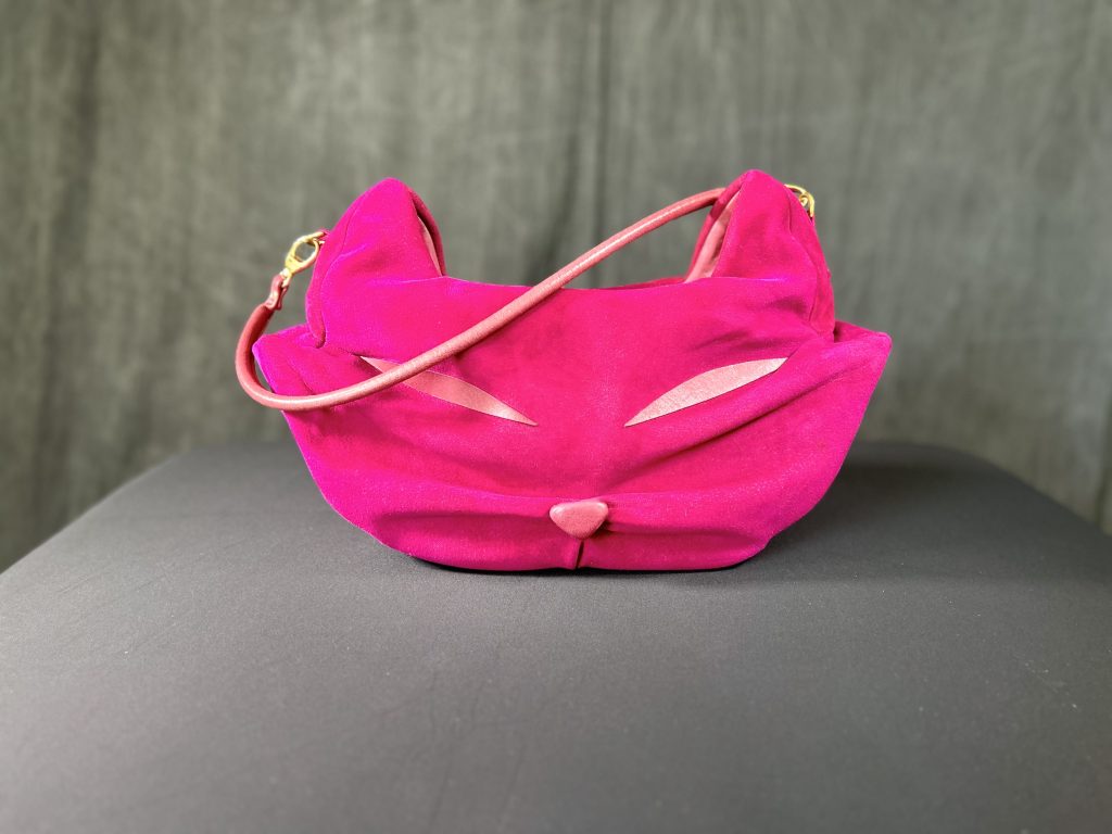 Hand-crafted hot pink suede Purberry purse prop with cat-ear details and gold hardware, designed for Gabby&rsquo;s Dollhouse.